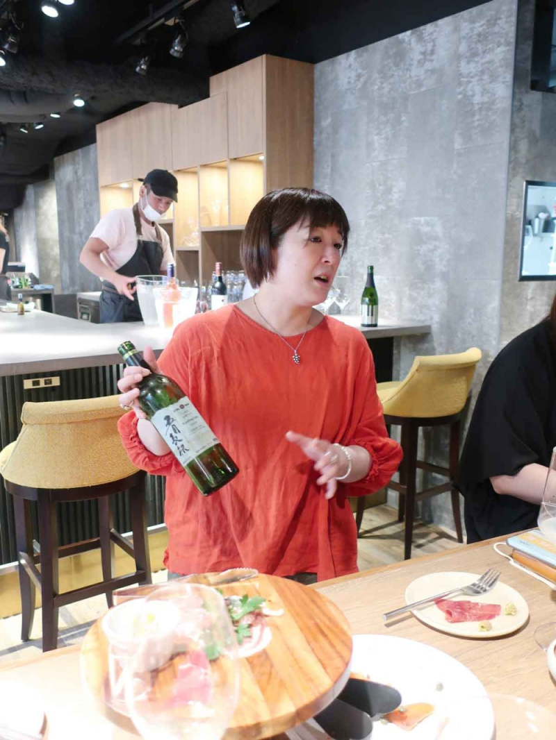 林やよいさんが持ち込みワインを説明しているところ